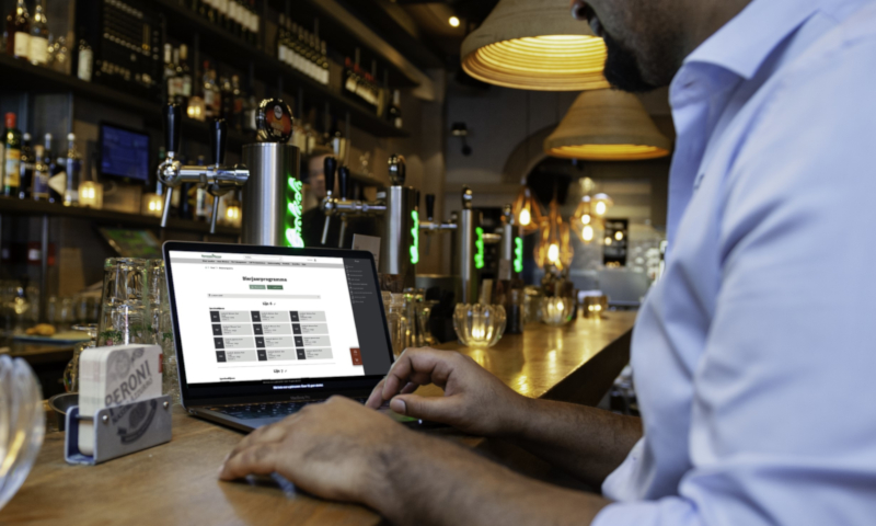 Grolsch bar binnen met man met laptop